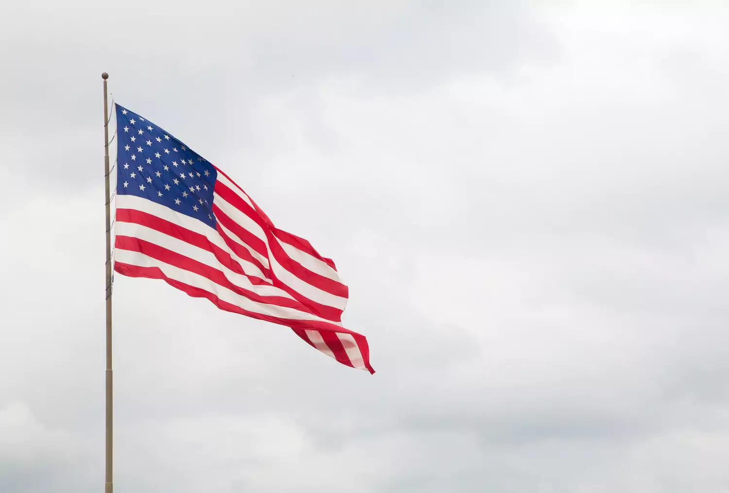 An American flag on a pole waves in the breeze. The sky in the background is overcast. Is there a place for patriotic songs in church worship? A better question is to ask how we might as shepherds teach our sheep how to be thankful for all of God’s blessings in a way that is obedient to Scripture and therefore honoring to the Lord.