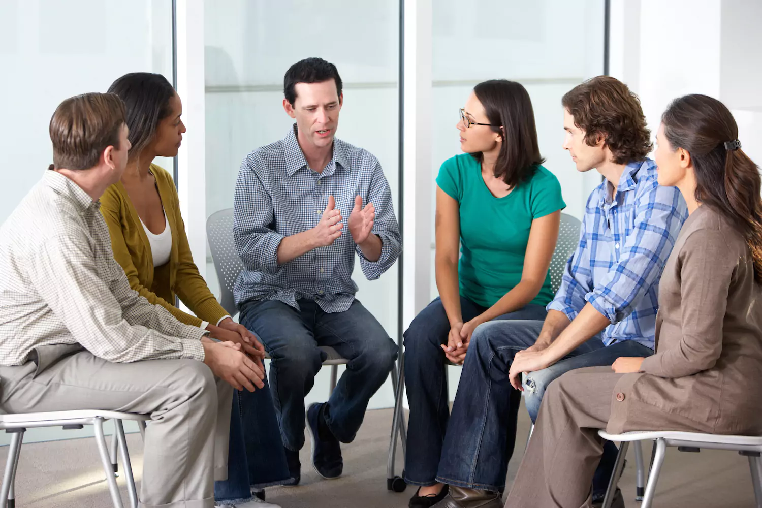 A photo of a pastor leading a c group of married couples in a marriage ministry.