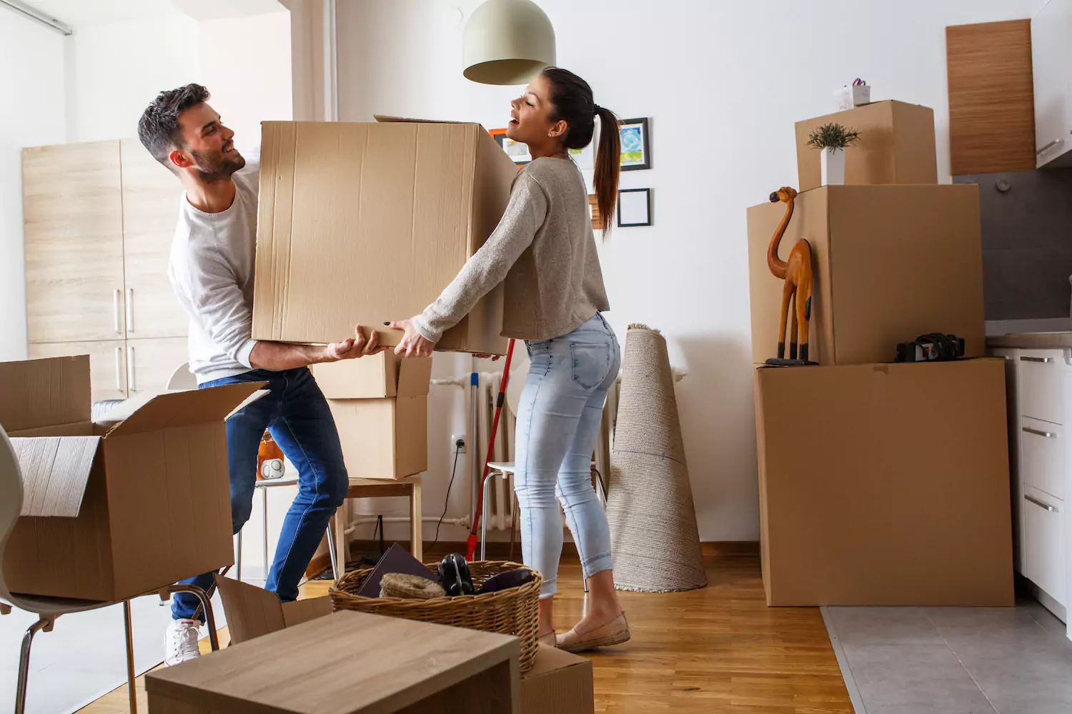 Husband and wife moving boxes into new home