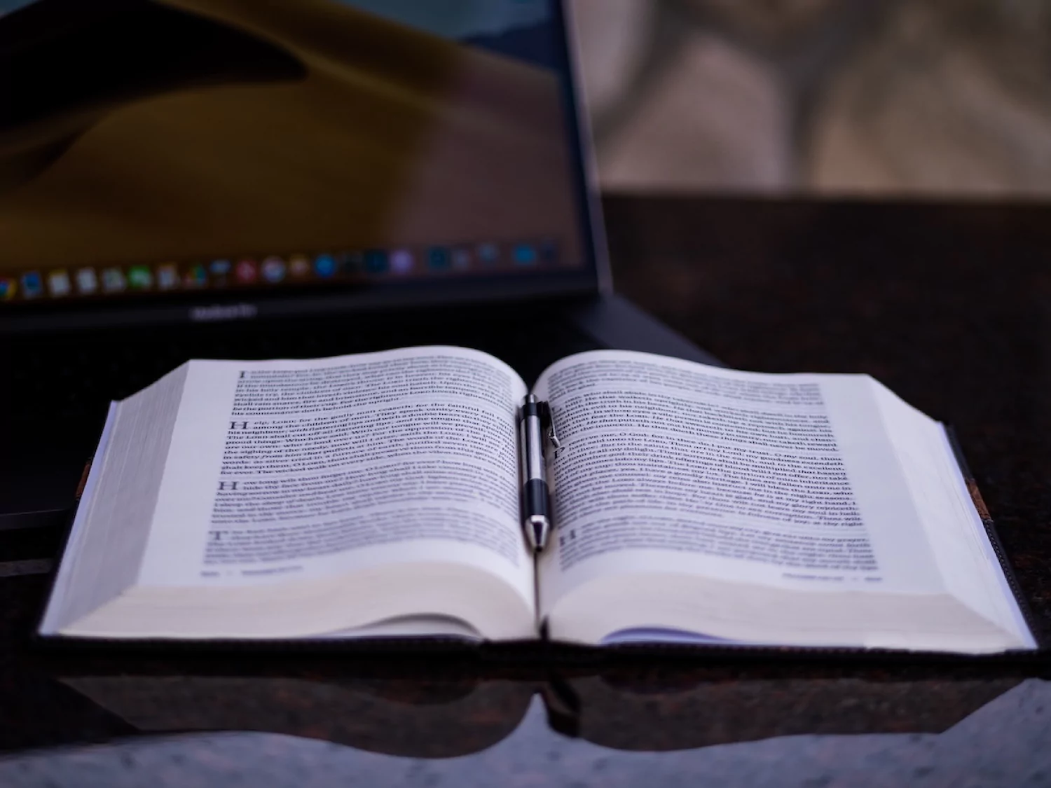 a bible lays open on top of a laptop, symbolizing the supremacy of Scripture to AI