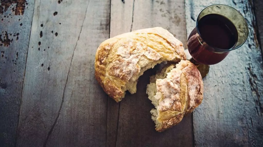 Communion bread and wine on a wooden table