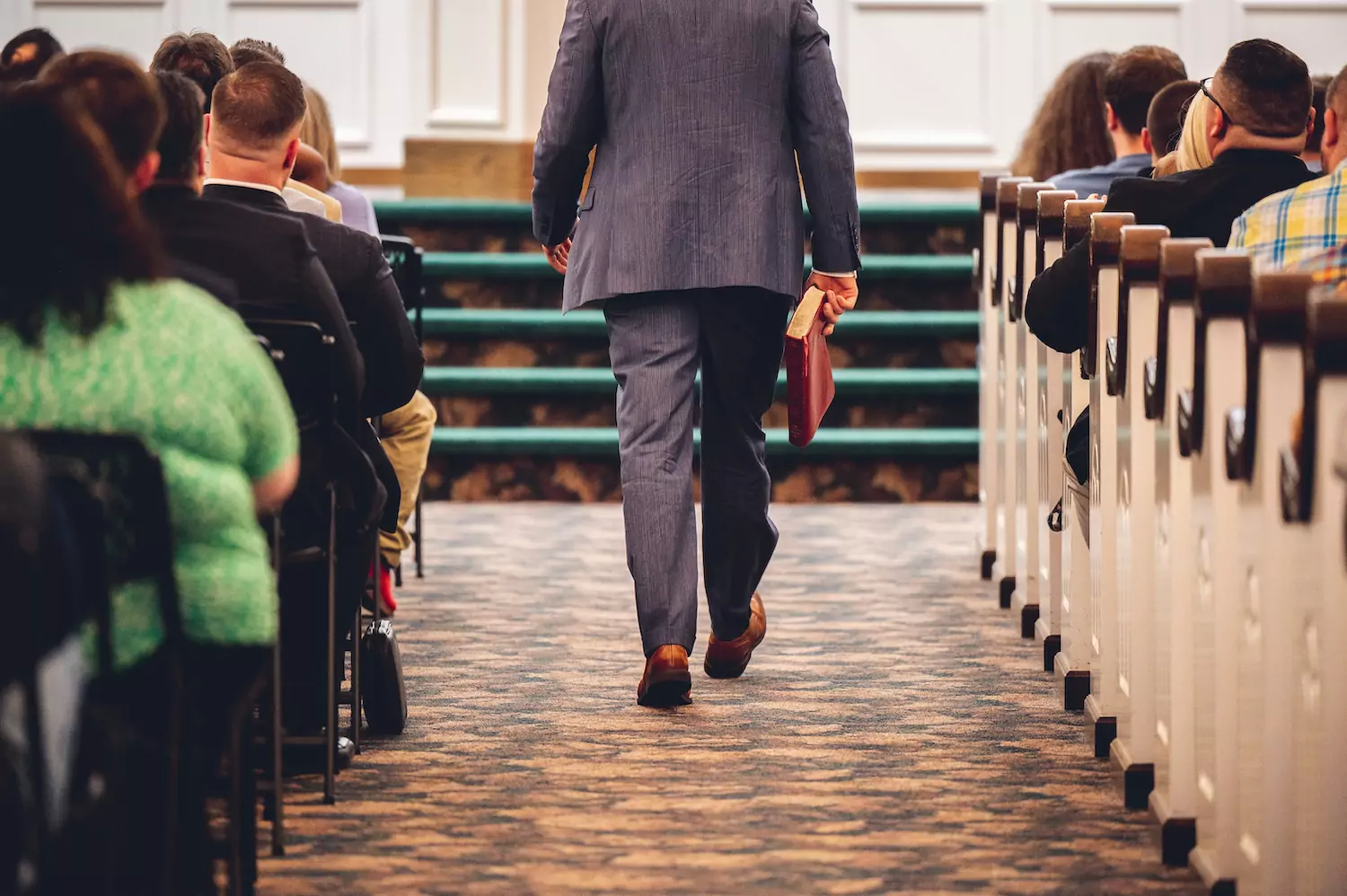 A pastor walks down the aisle of his church to preach.