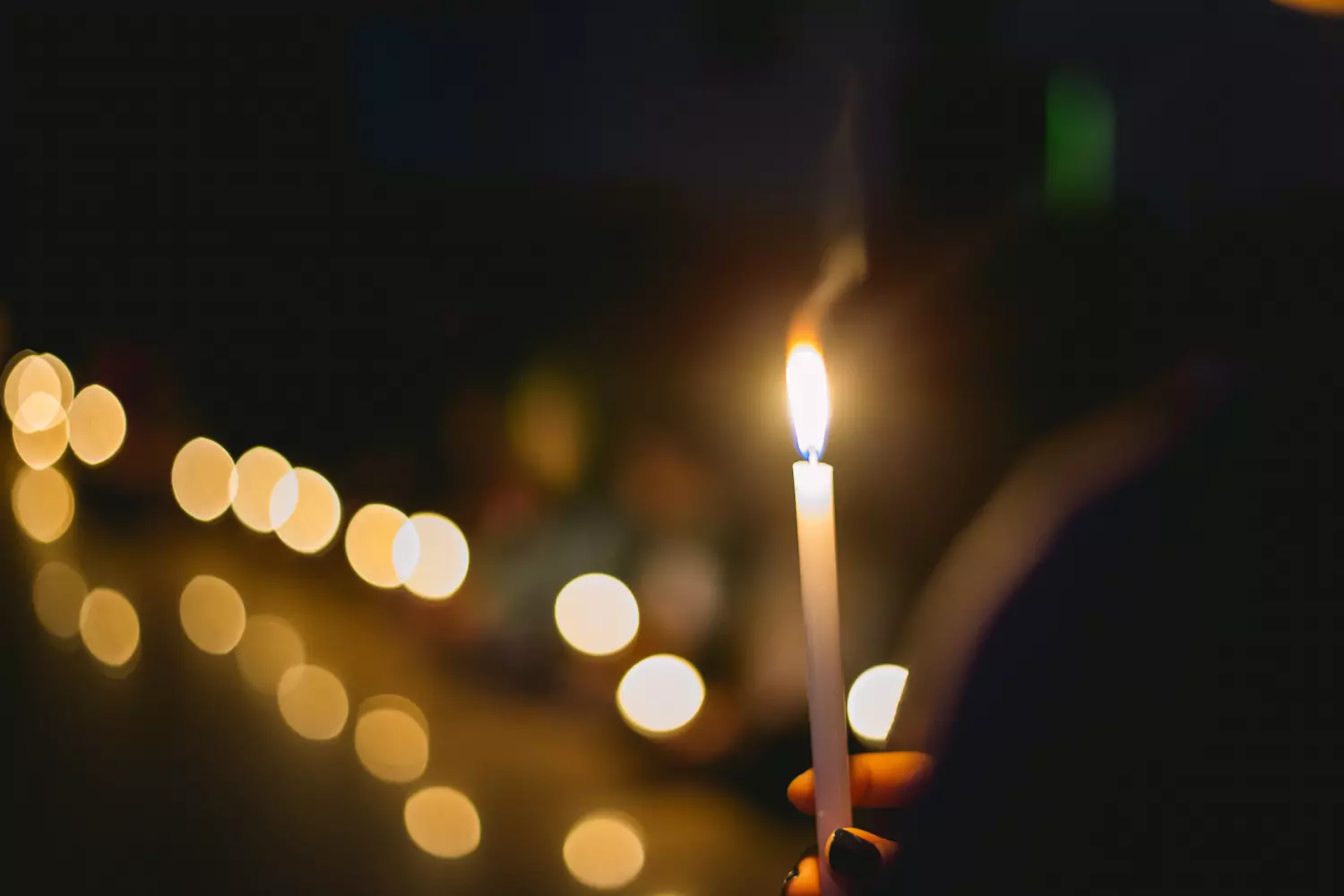 A churchgoer holds a lit candle at a Christmas Eve service.