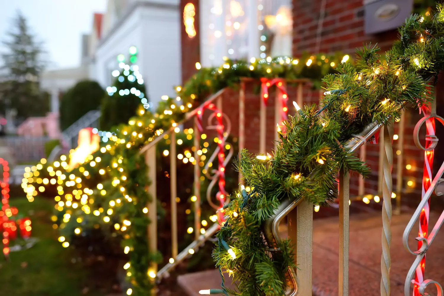 Neighborhood homes decorated with garland and Christmas lights.