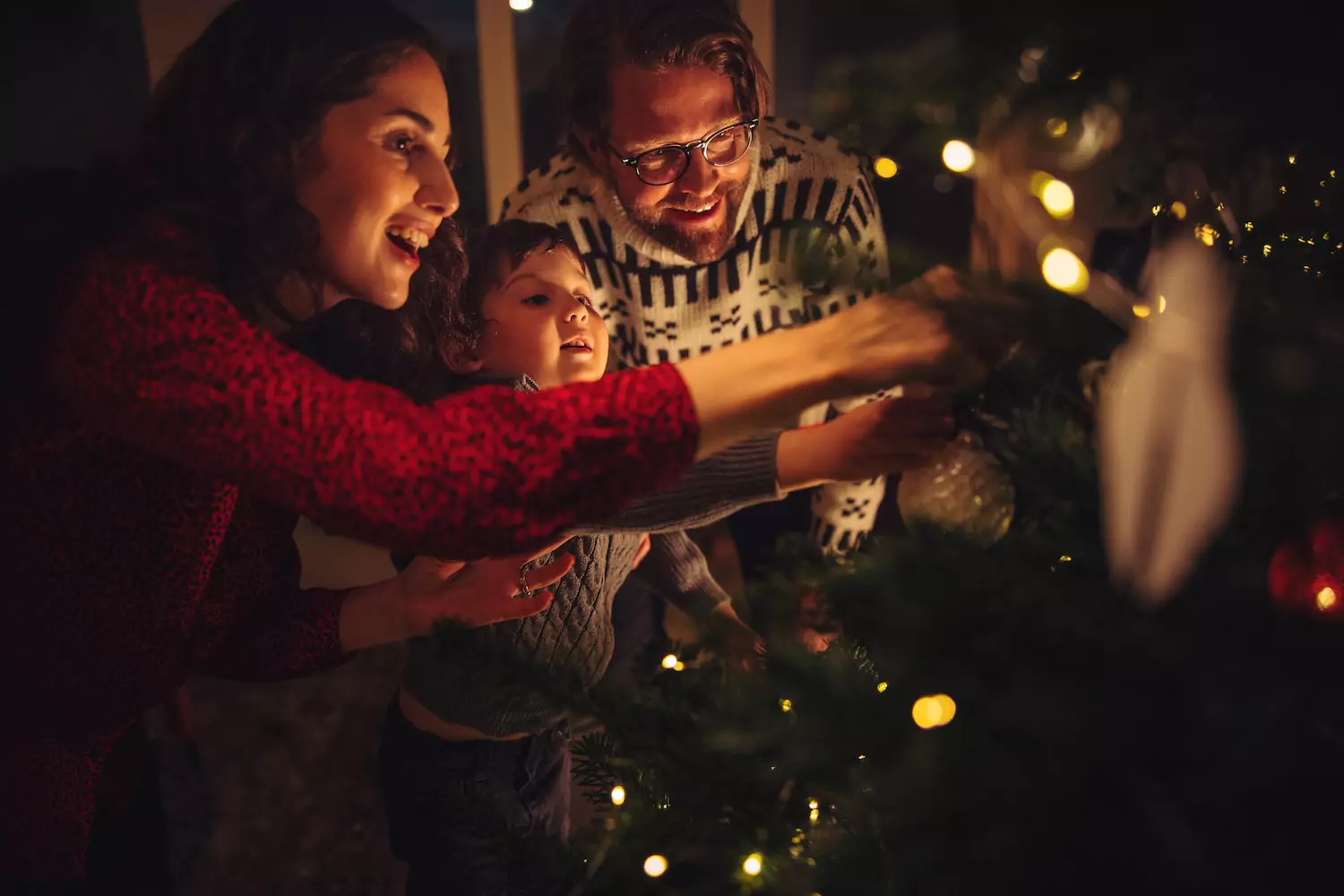 A pastor hangs Christmas ornaments with his wife and son, meditating on the love of advent together.