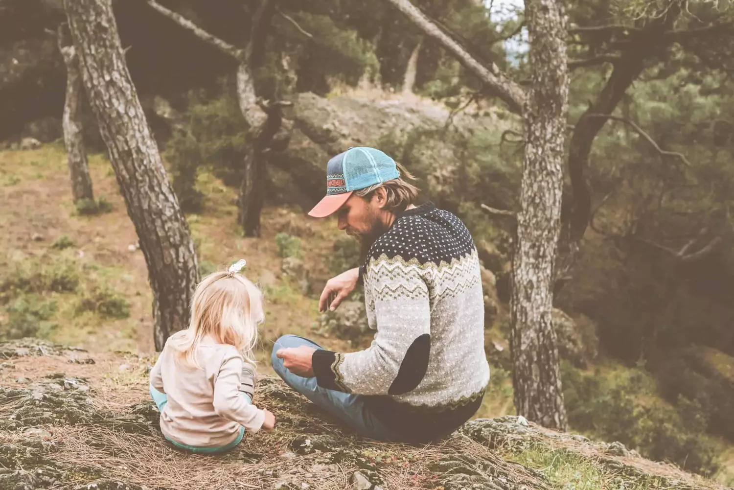 A pastor sits outside with his adopted baby girl.